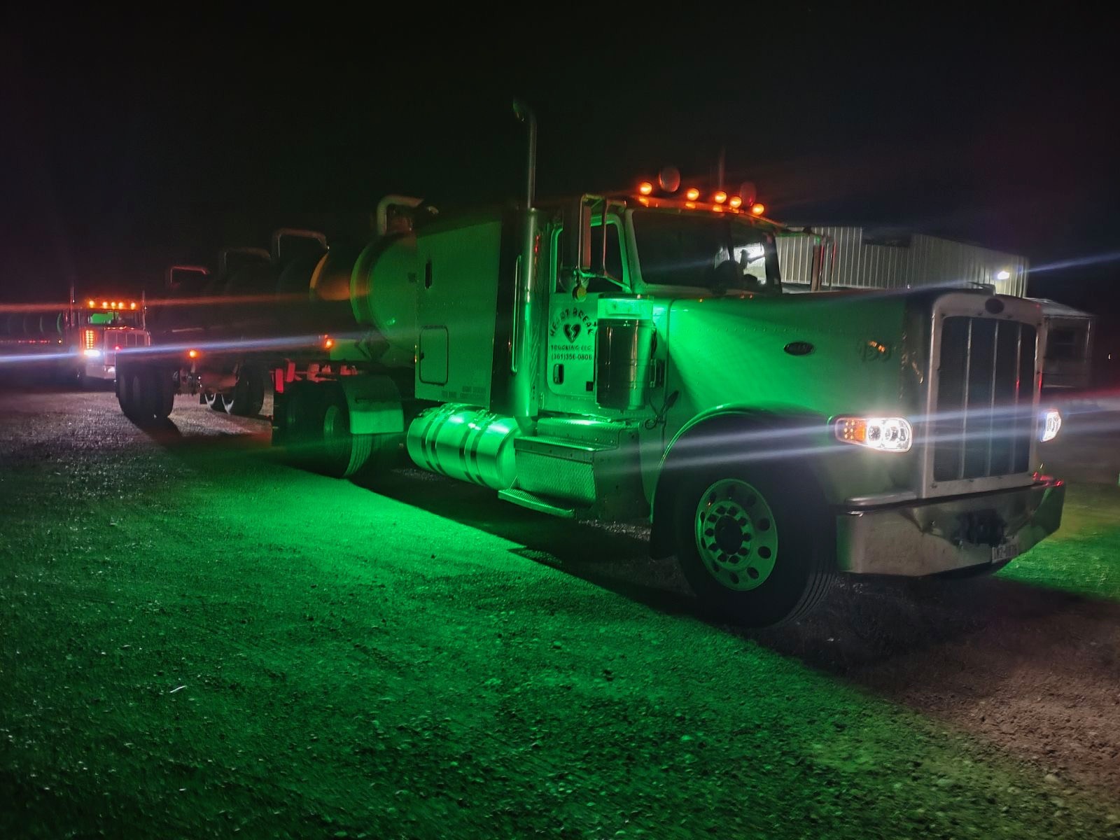Truck with green glow at the yard at night